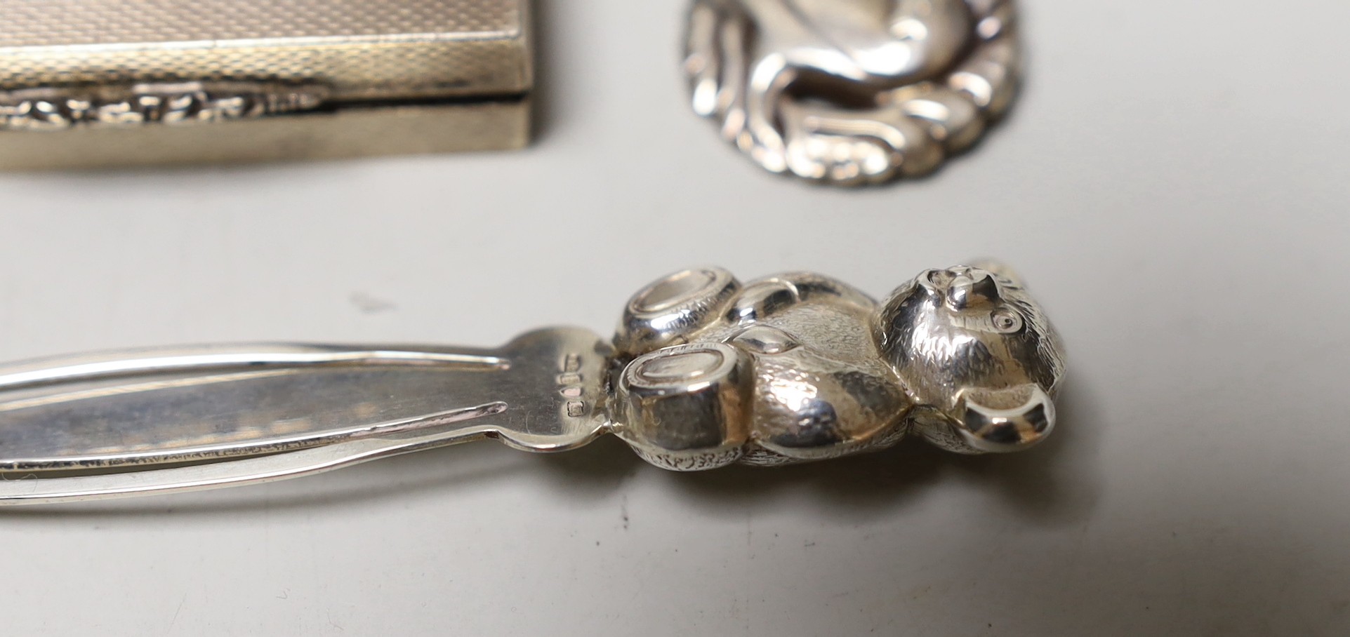An Art Nouveau metal mounted cork stopper, a Georg Jensen sterling brooch, no. 191, an engine turned silver box and novelty bookmark.
